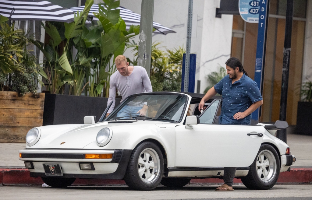 Edwin Castro sis pictured with a friend as they board his vintage Porsche convertible in Los Angeles