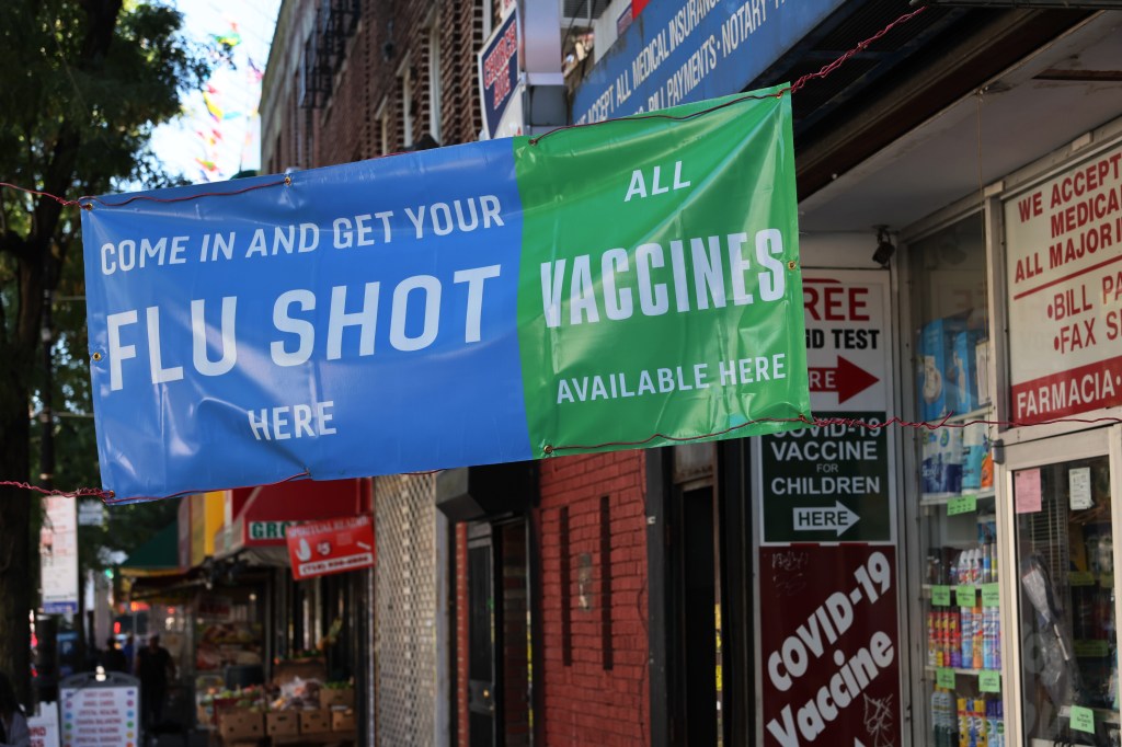 A sign outside a Brooklyn pharmacy advertises vaccines, as COVID-19 cases have risen since July.
