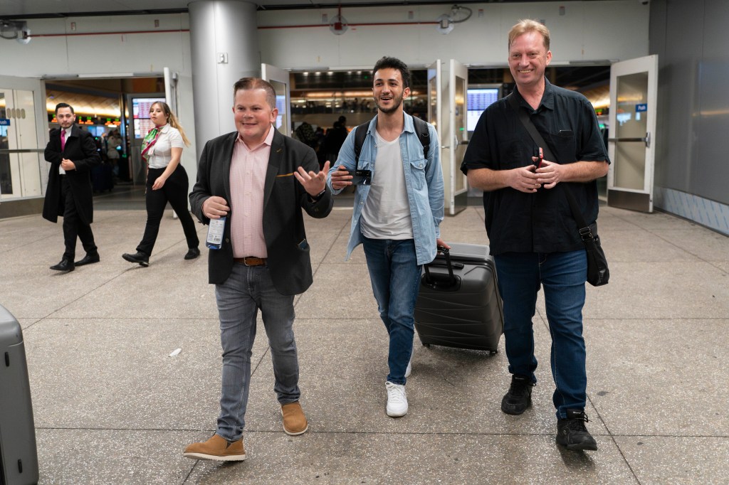 Michael White, Mahdi Vatankhah and Jonathan Franks, a consultant in the U.S. for families of American hostages and detainees, leave a terminal at the Los Angeles International Airport.