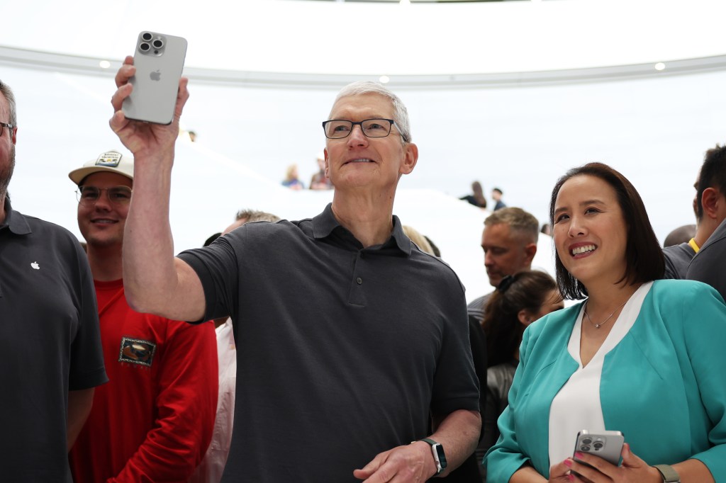 Tim Cook holding up new iphone
