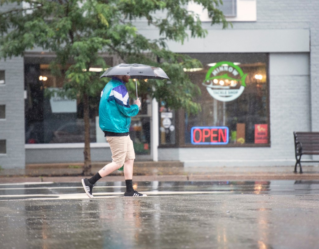 A pedestrian deals with the rain from Lee in Fredericton, New Brunswick. 