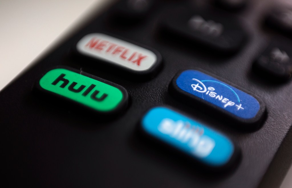 Logos for streaming services Netflix, Hulu, Disney Plus and Sling TV on a remote control.