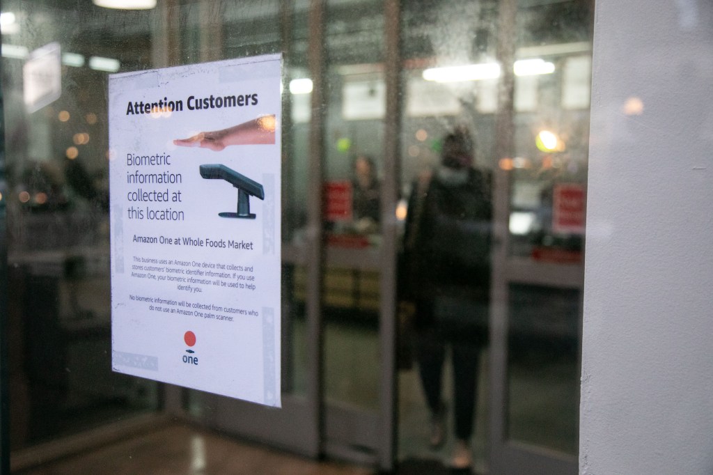 A sign warning customers of biometric data collection by the Amazon One palm scanner is displayed at a Whole Foods in New York, US, on Friday, Feb. 2, 2024.