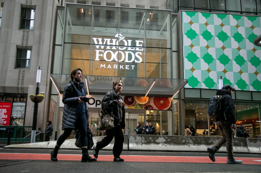 Pedestrians pass in front of a Whole Foods in New York, US, on Friday, Feb. 2, 2024